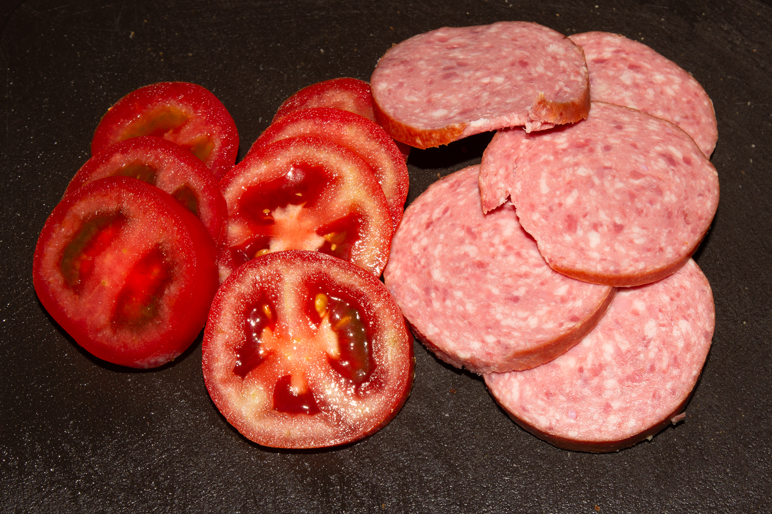 нарезанные продукты по рецепту Горячие бутерброды с колбасой, сыром и помидорами