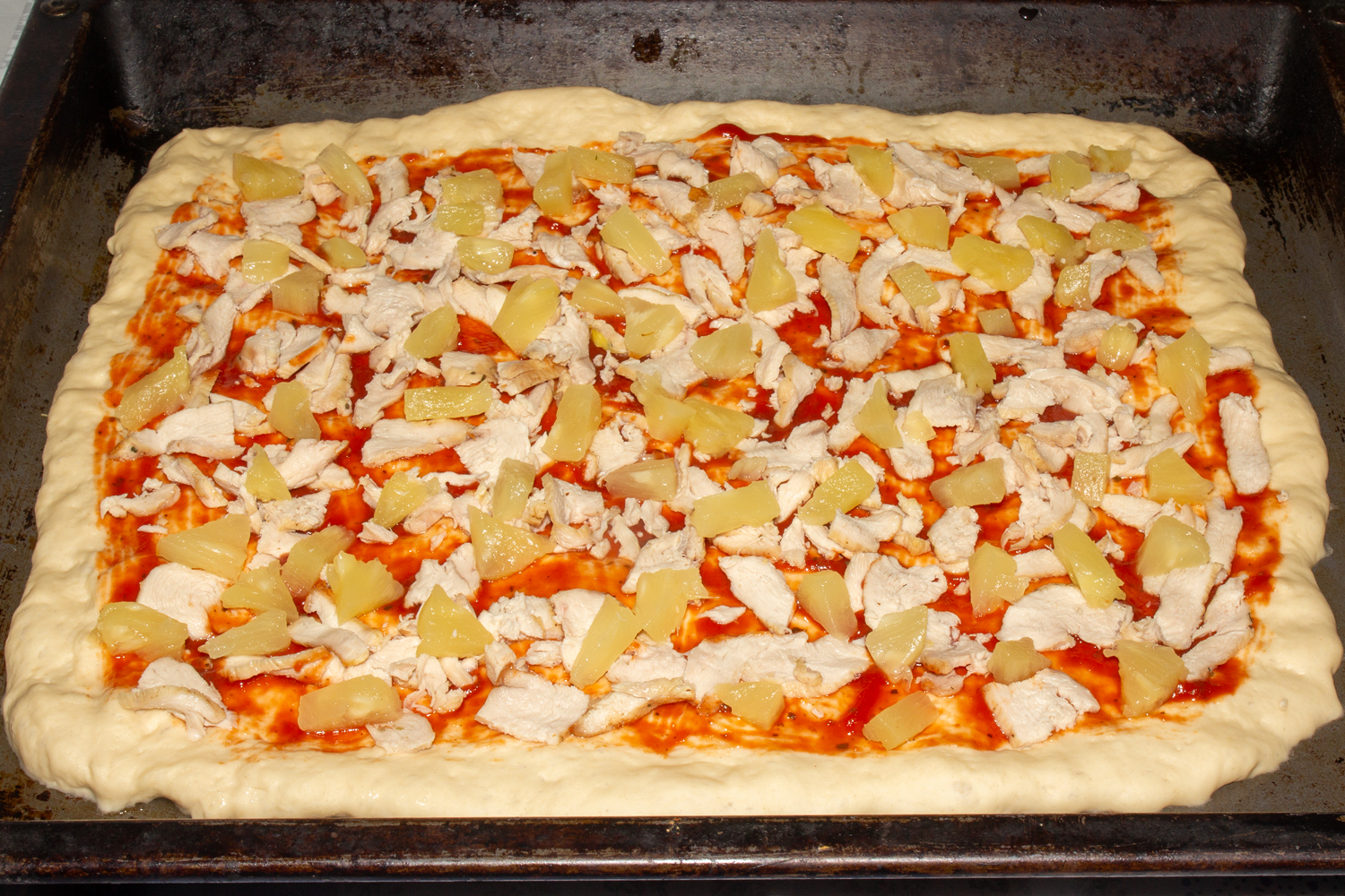 ингредиенты нарежьте и выложите на соус по рецепту Пицца Гавайская продукты выложенные на соус по рецепту Пицца Гавайская