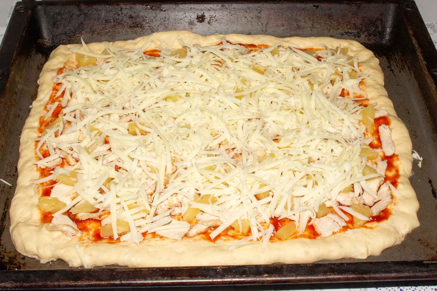 посыпьте пиццу сыром по рецепту Пицца Гавайская пицца посыпанная сыром по рецепту Пицца Гавайская