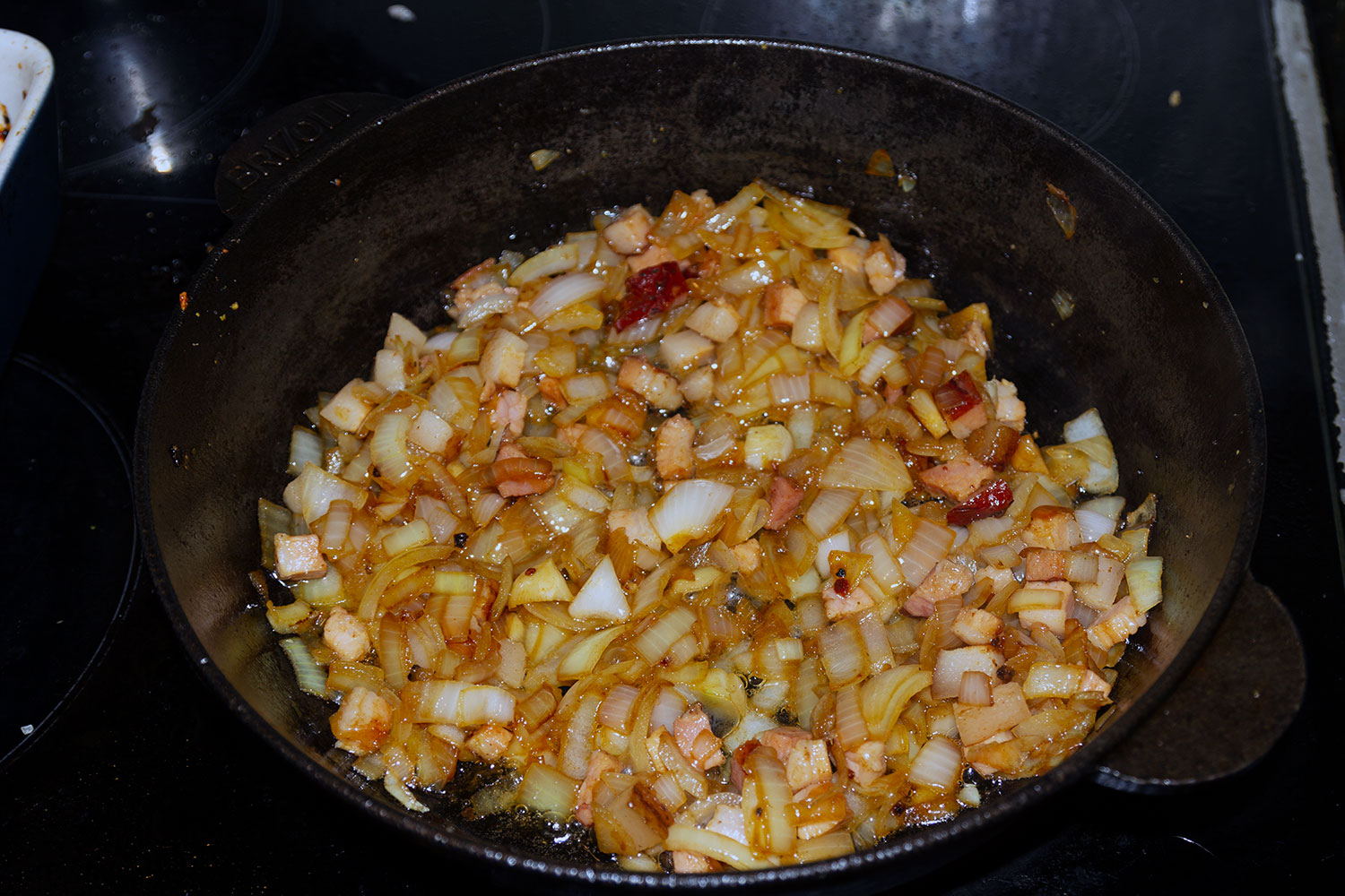 Обжарить лук и бекон для рецепта Кролик по-средиземноморски