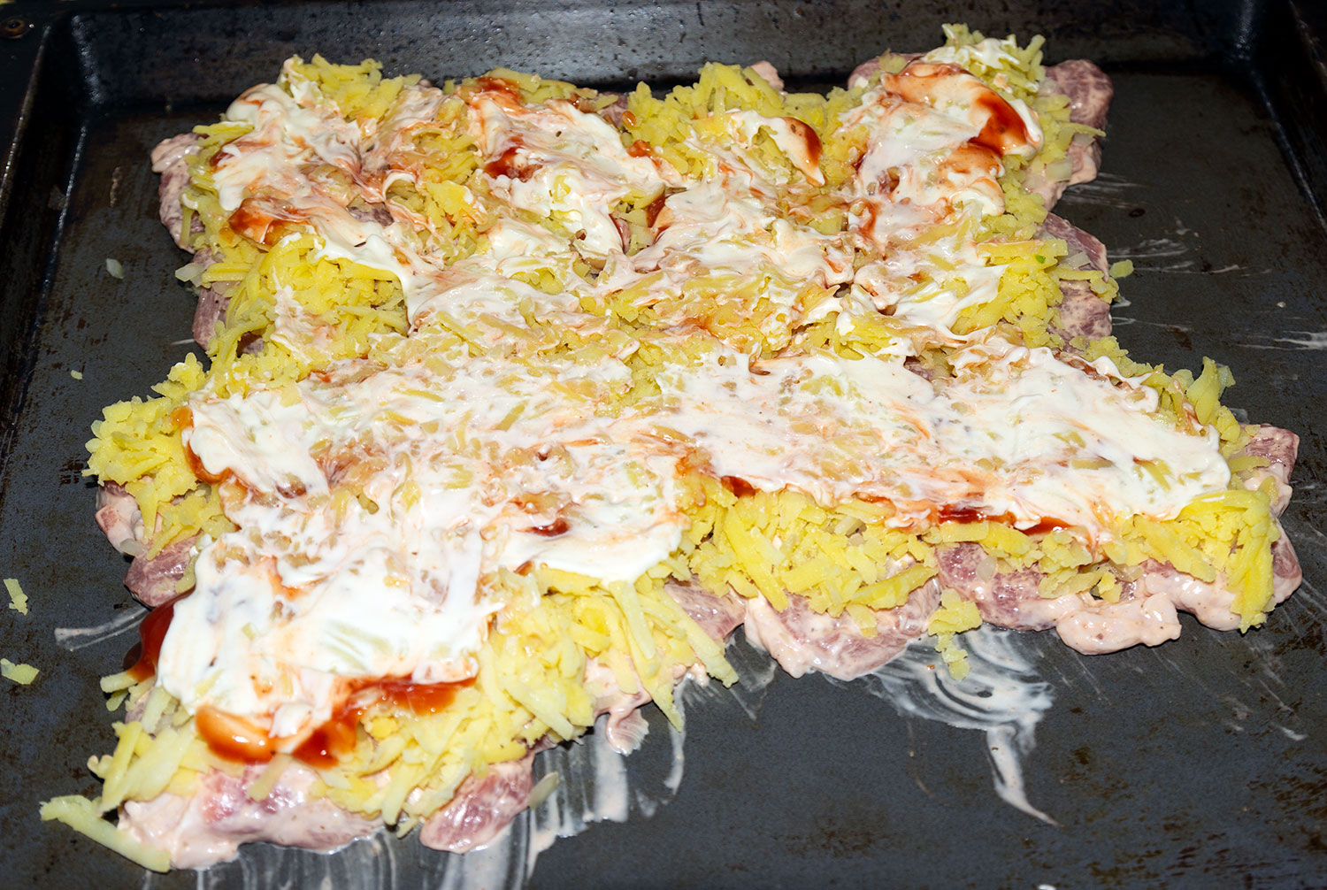 Выложить на мясо слоями картофель и соус по рецепту