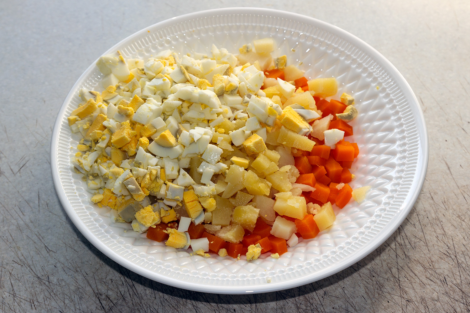 Нарезаем картофель, морковь и яйца для салата с горбушей