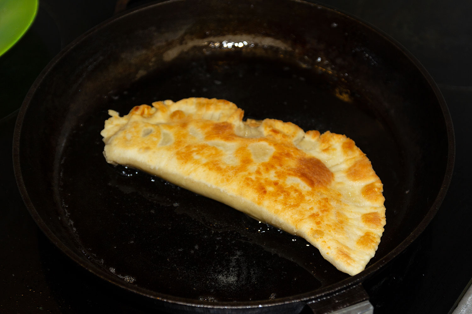 Обжаренный чебурек в масле для рецепта Чебуреки с ветчиной, колбасой, сыром и помидорами Обжариваем чебуреки на разогретой сковороде для рецепта Чебуреки с ветчиной, колбасой, сыром и помидорами