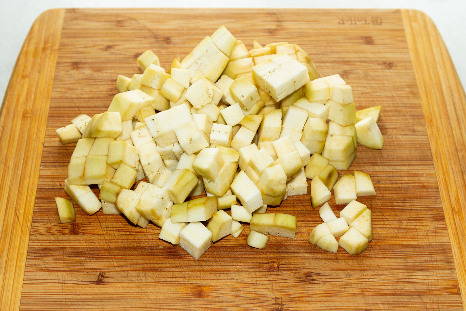 Очистить баклажан от кожуры и нарезать кубиками для рецепта