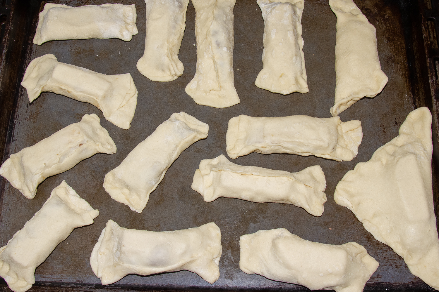 Конвертики с курином филе в тесте выкладываем на противень по рецепту Куриное филе в слоеном тесте